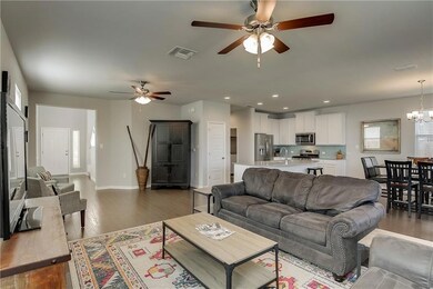 Living area with a ceiling fan, dark wood-style f
