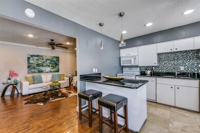Kitchen featuring white appliances, ceiling fan, t