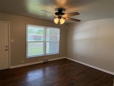 Unfurnished room featuring a ceiling fan and dark wood finished floors