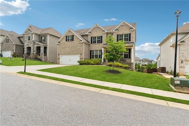 View of front of property with brick siding, a residential view, driveway, and a garage
