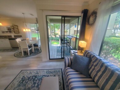 Living room with healthy amount of natural light, wood finished floors, and crown molding