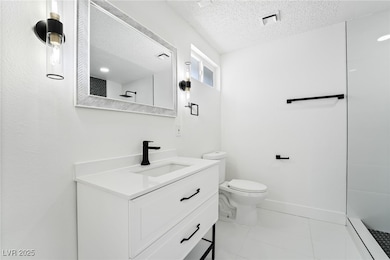 Bathroom with vanity, toilet, a textured ceiling,