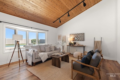 Living area with rail lighting, wooden ceiling, wood finished floors, and high vaulted ceiling