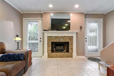 View of fireplace in living room with two doors to