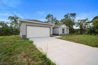Ranch-style home featuring stucco siding, driveway, a front yard, and a garage