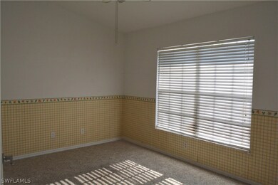 Office or den with window looking out front yard and door into foyer