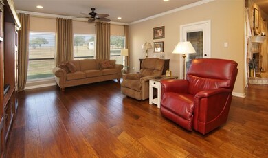 Living room featuring ornamental molding, dark hardwood / wood-style flooring, and plenty of natural light