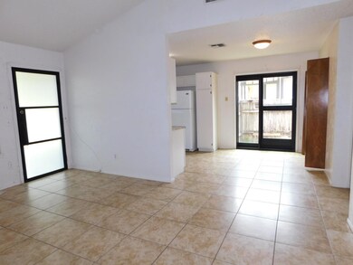 Empty room featuring vaulted ceiling, visible ven
