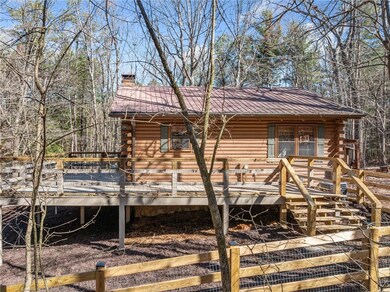 Rear view of property featuring a chimney, a deck,