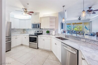 This elegantly appointed kitchen showcases updated stainless steel appliances and expansive marble countertops, offering both sophistication and functionality. Large-format tile floors flow seamlessly throughout the space, enhancing its modern appeal and easy maintenance. The crisp white cabinetry provides abundant storage, while the open breakfast bar invites effortless entertaining. From this vantage point, enjoy sweeping views of the shimmering lake and resort-style amenities, creating a truly elevated c