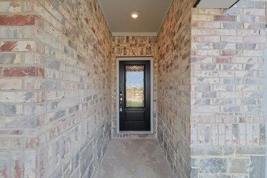 This gorgeous home offers a covered porch with a beautifully upgraded front door.