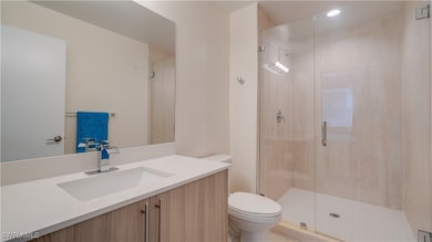 Bathroom with vanity, toilet, and walk in shower