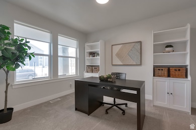 Office featuring visible vents, light carpet, and baseboards