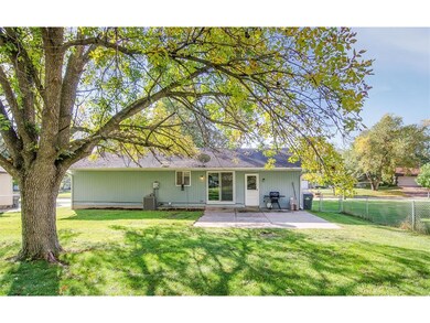 Rear View of home with a flat back yard that is fu