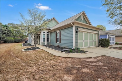 View of front of house with driveway, an attached garage, and central AC