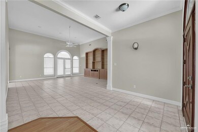 Spare room with ornamental molding, light wood finished floors, and a ceiling fan
