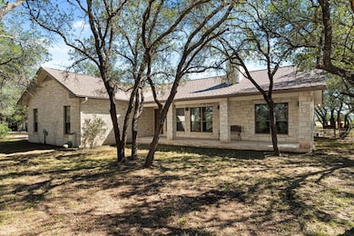 Rear view of property with stone siding, a shingl