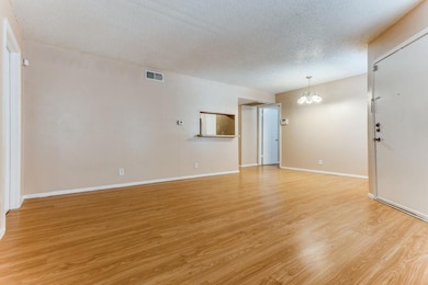 Empty room with a textured ceiling, an inviting ch