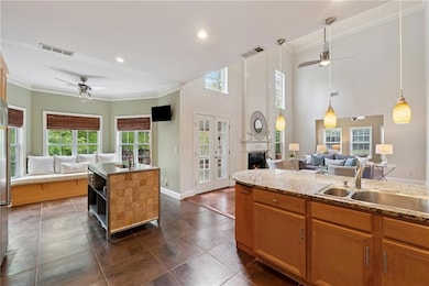 Kitchen featuring open floor plan, a sink, and a ceiling fan