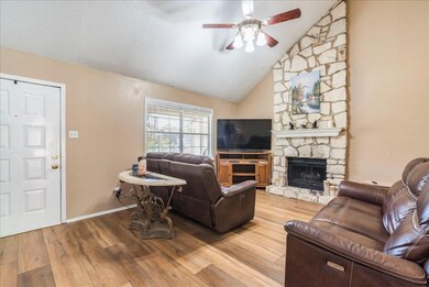 Living area with ceiling fan, a fireplace, a text