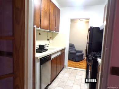 Kitchen featuring light countertops, gas stove, dishwasher, and brown cabinets