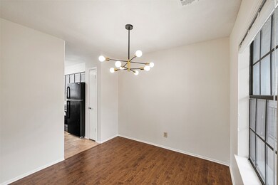 Unfurnished dining area featuring wood finished floors and a chandelier