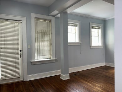 Entrance foyer featuring baseboards, hardwood / wood-style floors, and crown molding