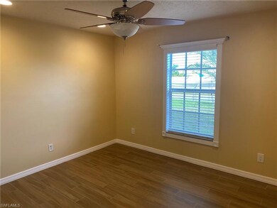 Empty room featuring a ceiling fan, baseboards, and dark wood finished floors