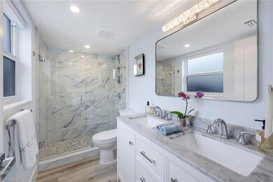 STUNNING Bathroom featuring new light flooring, double sink vanity, toilet, and an enclosed shower