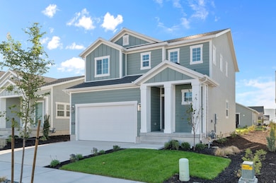 View of front of home with board and batten siding, a garage, driveway, and a front yard