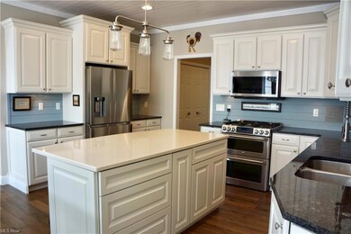 Updated Kitchen, granite countertops, wood floors and large island with quartz counter, double oven/gas range