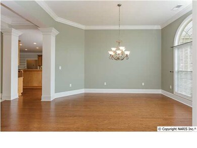 Columns add an elegant touch to this formal dining room with lots of moulding, hardwood floors and transomed windows.