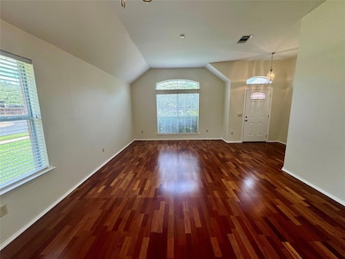 Unfurnished living room with dark wood-style flooring and vaulted ceiling