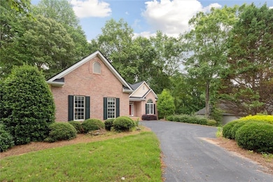 Traditional-style home featuring brick siding, view of scattered trees, and a front lawn
