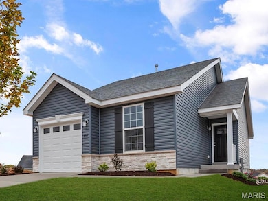 View of front facade featuring a garage and a front yard