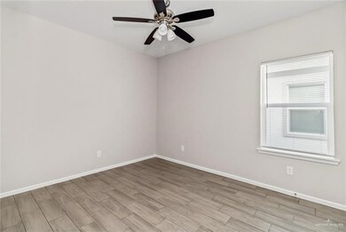 Empty room featuring light wood-type flooring and a ceiling fan