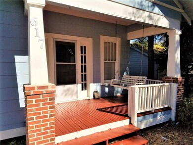 beautiful newly painted red porch with porch swing