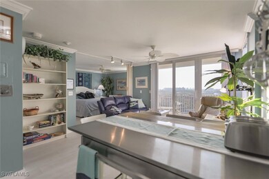 Living room with ceiling fan, rail lighting, crown