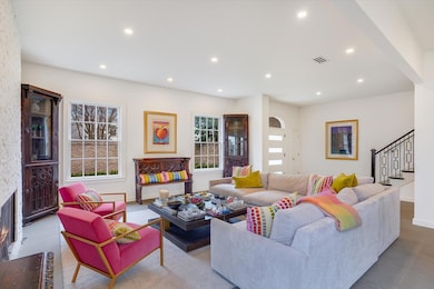 Living area featuring a stone fireplace, stairway