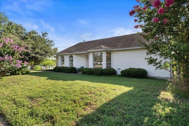 View of property exterior with a lawn, brick sidi