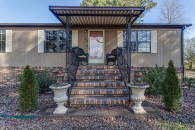 A pea gravel sidewalk leads to the front porch with iron railings.