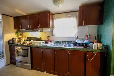 Kitchen with sink and stainless steel range with electric cooktop