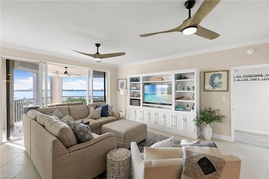 Living room with ceiling fan, crown molding, and l