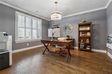 Office featuring crown molding, wood-type flooring, baseboards, and a chandelier