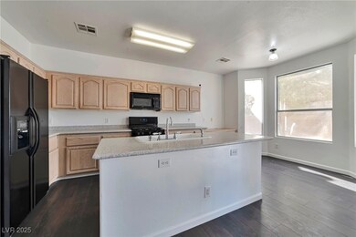 Kitchen featuring black appliances, a sink, light