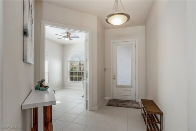 Foyer entrance with a ceiling fan, light tile patt