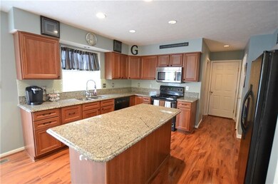Kitchen features granite counters, glass tile back