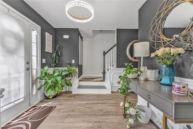 Entrance foyer with wood finished floors, stairway, and plenty of natural light