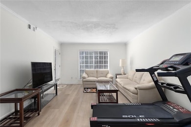 Living room featuring a textured ceiling, light wo