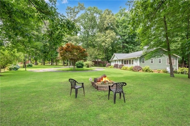 View of grassy yard featuring an outdoor fire pit